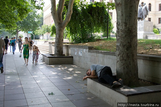 Человек прилег отдохнуть на скамейке. Тбилиси, Грузия
