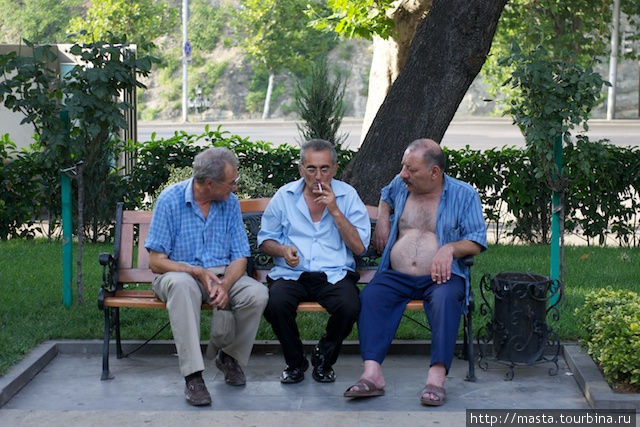 Местные жители сидят на скамейке в парке Гейдара Алиева. Тбилиси, Грузия