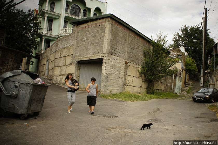 Девочка с мальчиком несут куда-то своего пса. Тбилиси, Грузия