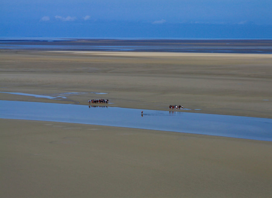 группы школьников гуляют по океаническому дну Мон-Сен-Мишель, Франция