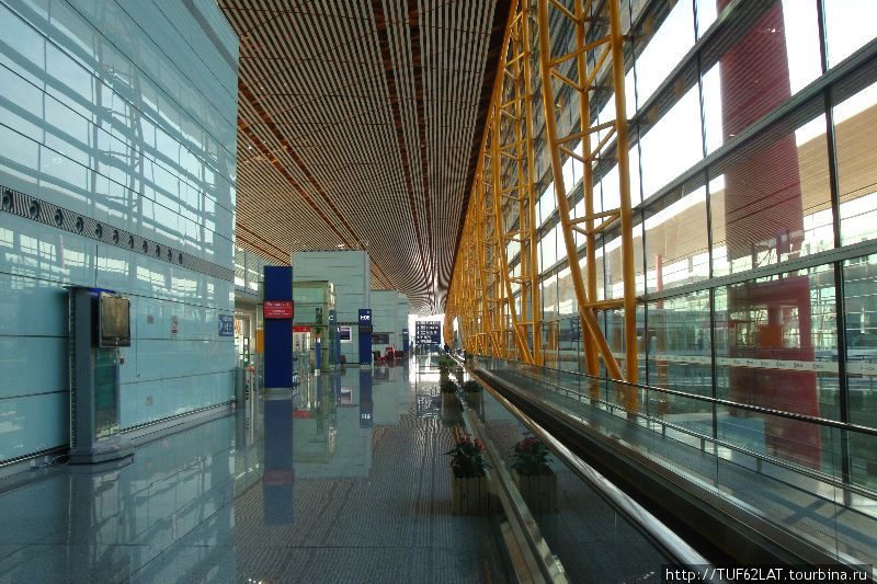 В огромных терминалах чистота.Люди могут передвигаться пешком, а так же на движущейся дорожке экскалатора. Пекин, Китай