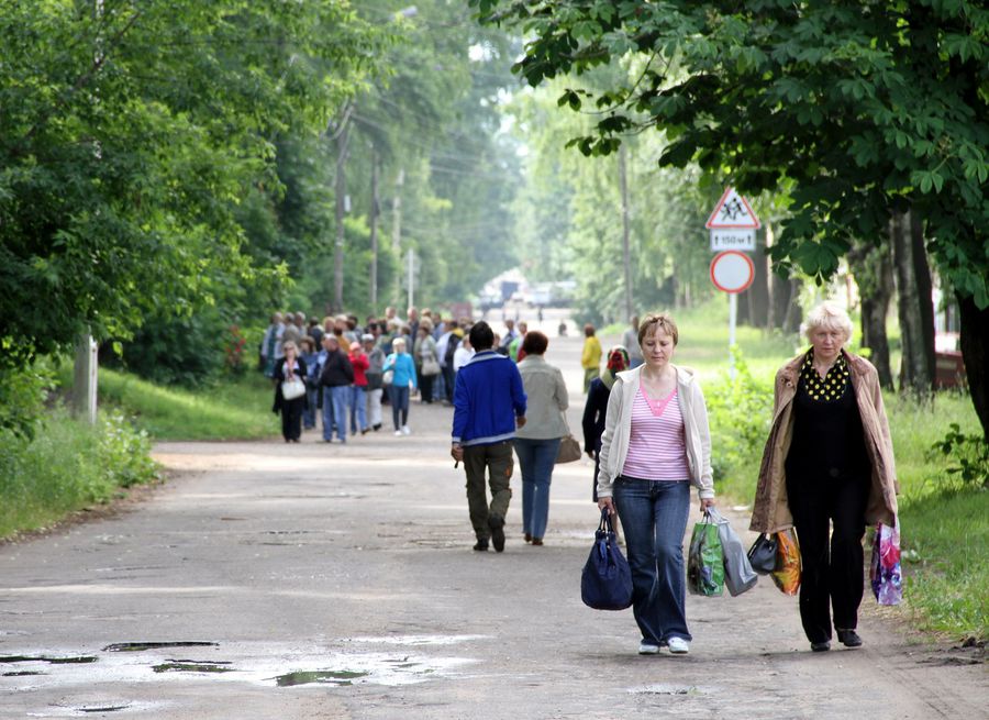 Местные жители (справа) и туристы вдалеке (слева) Осташков и Озеро Селигер, Россия