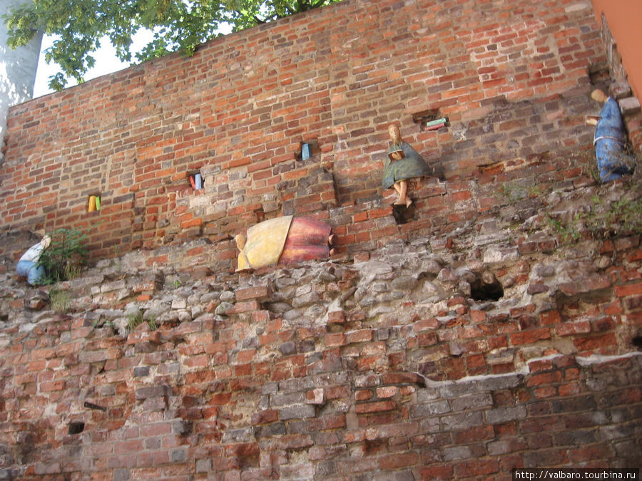 Персонажи средневекового города на городской стене улицы Подмурна. Торунь, Польша