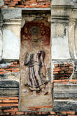 Статуя идущего Будды на боковой стене пранга на территории Вата Пхра Рам в Аюттхае