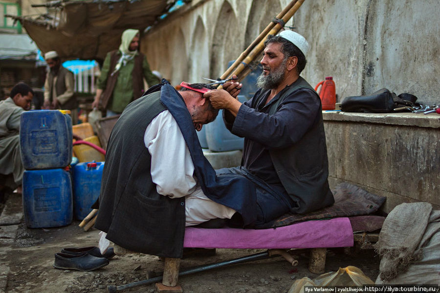 Среди торговых рядов работают уличные парикмахеры. Кабул, Афганистан