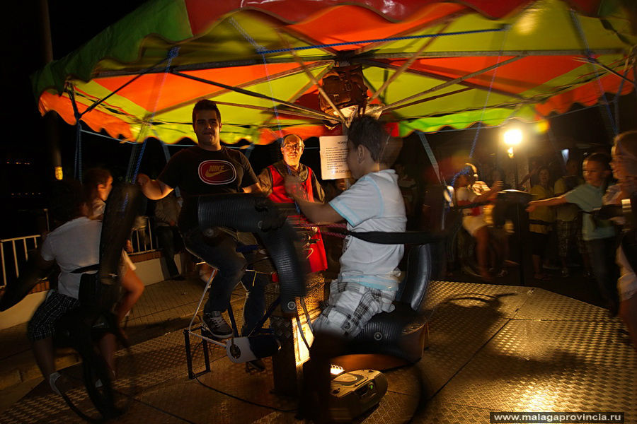 Экологичная карусель — сидит парень и крутит педали — карусель вращается на радость детям Малага, Испания