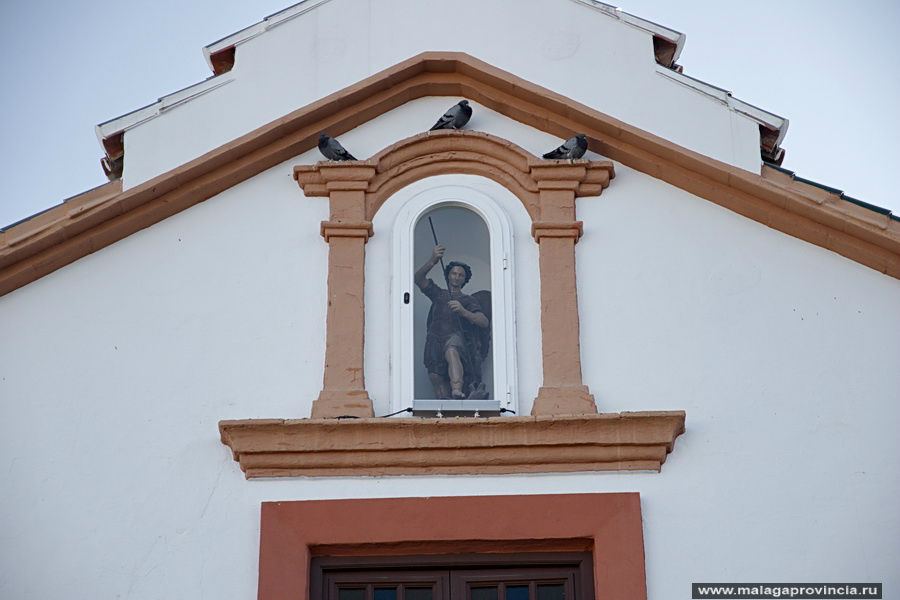 Сан Мигель или Архангел Михаил, поражающий копьем змия на фасаде одноименной церкви 15-го века Малага, Испания
