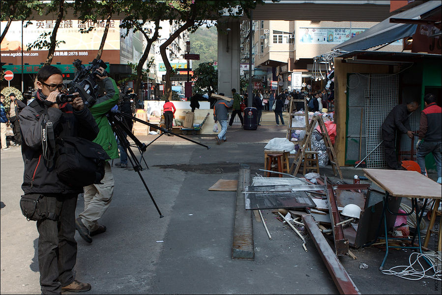 Вернувшись немного назад, но свернув на соседнюю улицу можно попасть на недавно почти полностью сгоревший вещевой рынок. Сейчас его активно восстанавливают, о чем, собственно, и снимают сюжет телевизионщики. Коулун, Гонконг