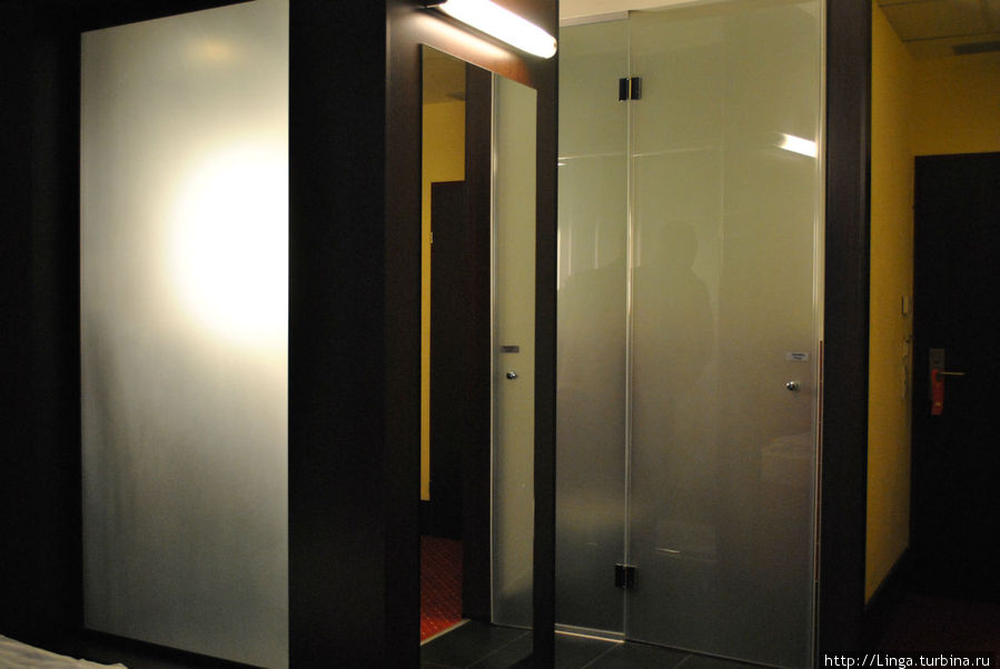 Светящееся матовое стекло слева — это задняя стенка душа, который находится в центре комнаты. Зальцбург, Австрия
