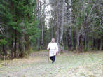 На лесной тропе показался мужик в белой рубахе-косоворотке с посохом в руке