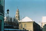 На переднем плане костёл Божией Матери Утешения (позднее барокко). Храм с единственной башней переднего фасада в Литве представляет собой достаточно редкое явление.