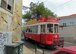 Экскурсионный трамвай красного цвета, похож по дизайну, но проезд в нем 9 евро