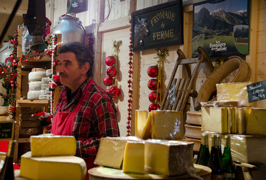 Продавец сыра на рождественском базаре в Гренобле Гренобль, Франция