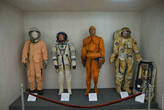 Слева направо: скафандр СК-1 (как у Гагарина во время первого полета), сокол КВ-2 (впервые применялся в 1980 г.), спасательный костюм “Форель” (в случае аварийного приводнения, человек может находиться в таком костюме на воде до трех суток), скафандр ОРЛАН-Д и ранец к нему (для выходов в открытый космос, эксплуатировался с 1977 по 1984 гг.)