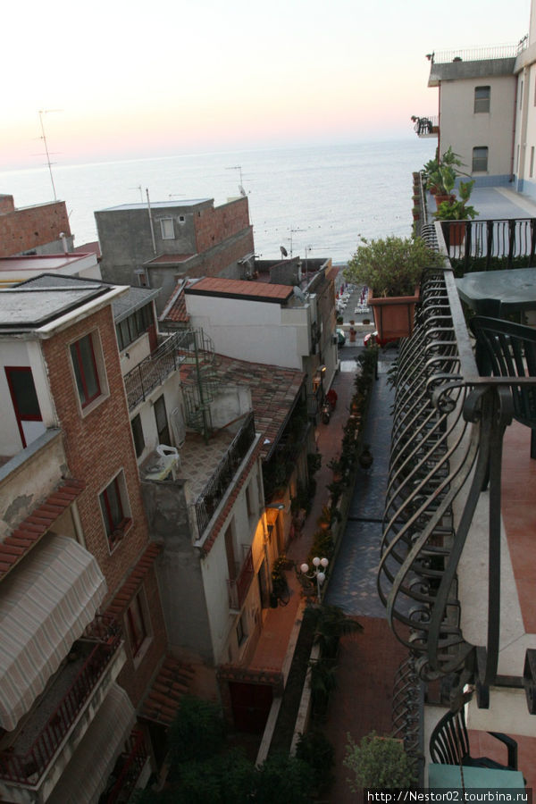 Вид с балкона на море и переулочек внизу. Сицилия, Италия