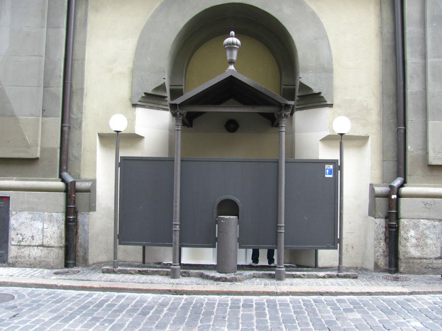 сбоку у стены башни расположился лёгкий мужской туалет Берн, Швейцария