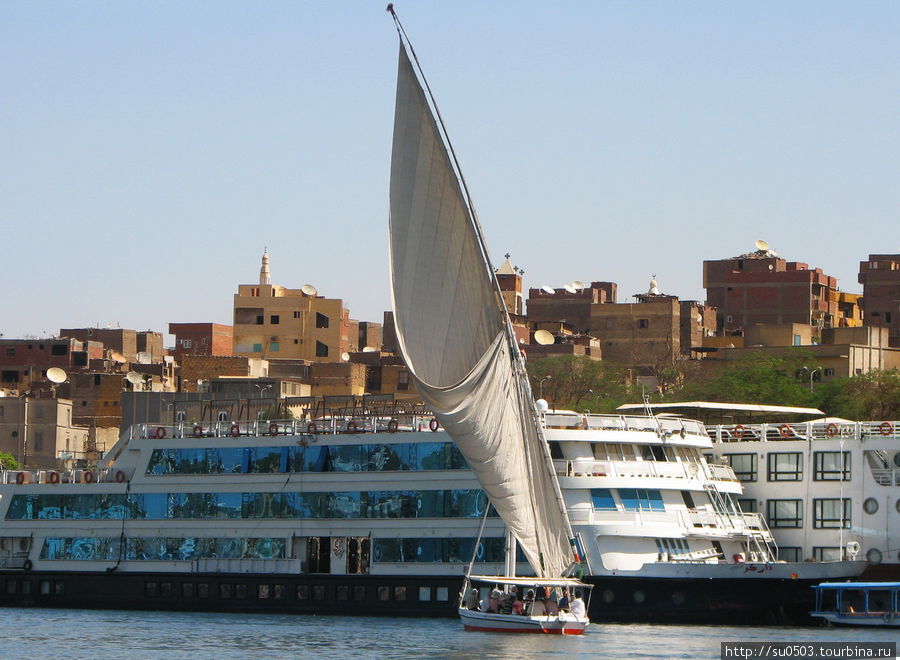 Фелука и круизный корабль у берега Асуана Египет