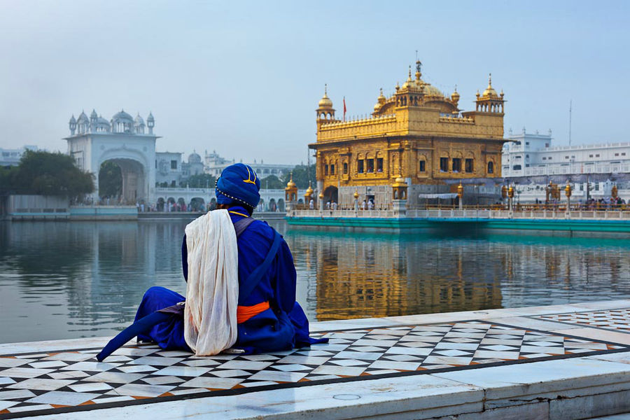 Воин сикхского ордена Ниханг, медитирующий рядом с храмом Хармандир Сахиб – Золотым храмом, главной святыней сикхов. Амритцар, штат Пенджаб Индия