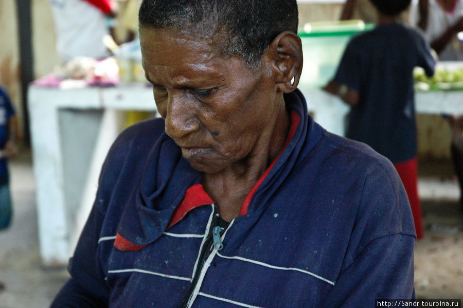 Пожилая женщина с “проколотыми” ушами. Она продает бетель. Папуа, Индонезия
