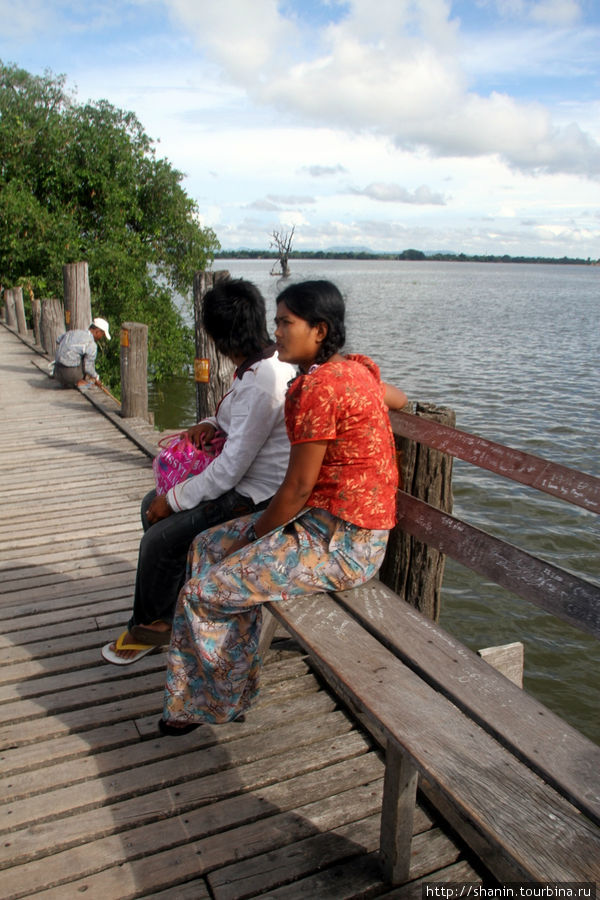 На мосту есть много лавочек, чтобы посидеть с видом Амарапура, Мьянма