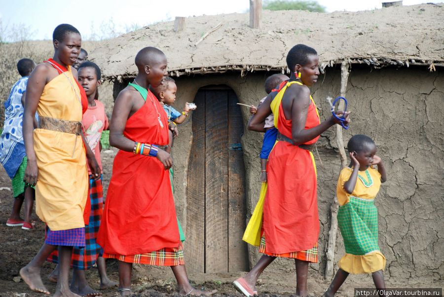 Девушки, даже продвигаясь по деревне, что-то припевали и прихлопывали в такт песне Масаи-Мара Национальный Парк, Кения