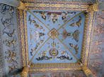 На голубом фоне потолка внутри арки расположились изображения будд, воинов и боевых слонов