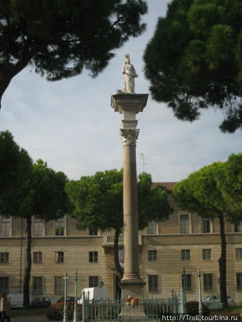 В центре круга, где машины совершают разворот, колонна с Богоматерью Равенна, Италия