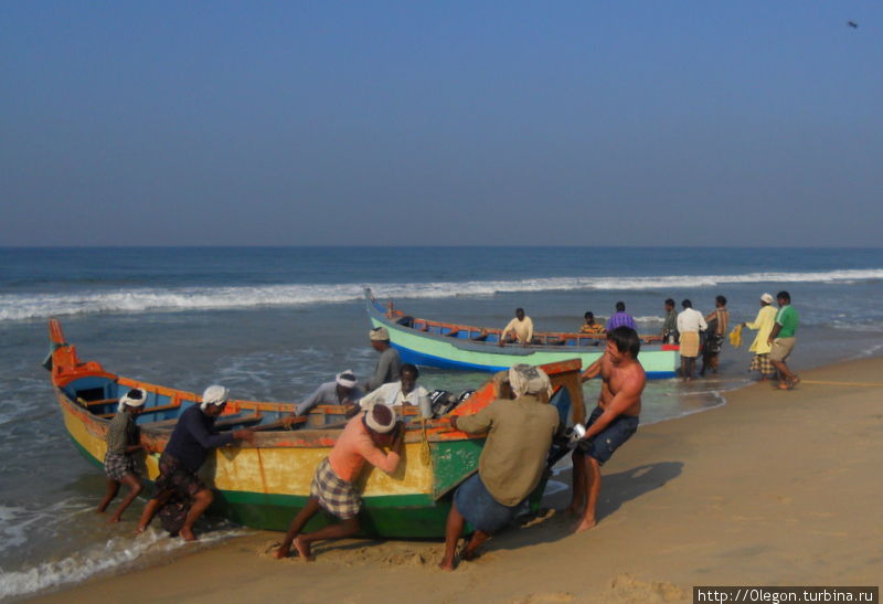Лодки очень тяжеленные, поэтому вытаскивать на сушу приходится нескольким людям Варкала, Индия