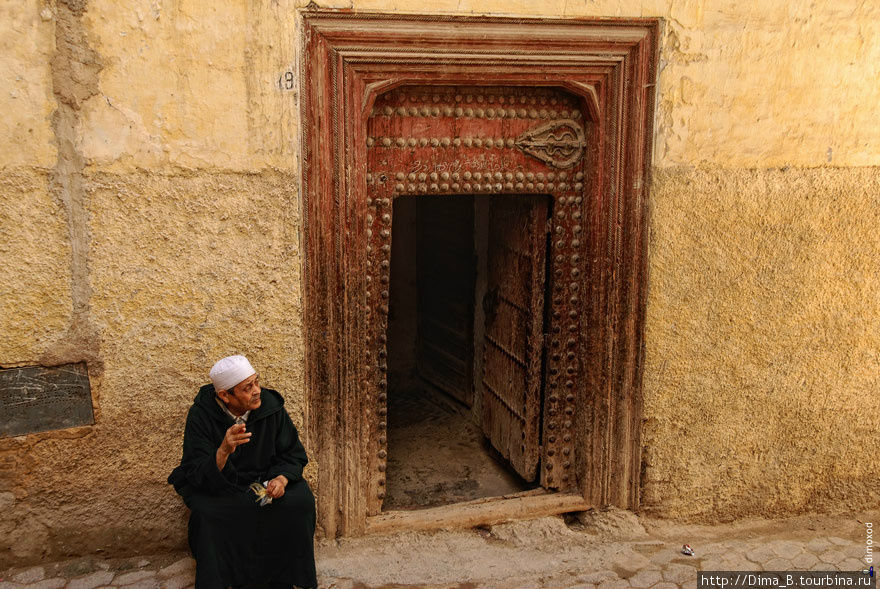 Человек, сидящий перед входом в храм. Фес, Марокко
