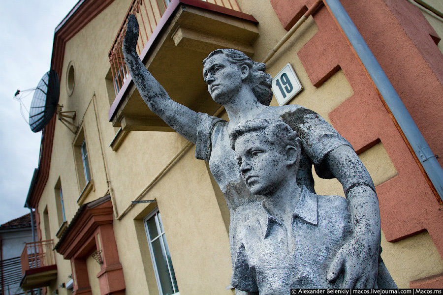 Еще одна отремонтированная сталинка. Во двор кто-то притащил каменную женщину с пионером. Женщинам машет рукой. Наверное, прощается с советским союзом. Вильнюс, Литва