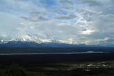За долиной и предгорьями виден Аляскинский хребет с большущей горой Маккинли по центру