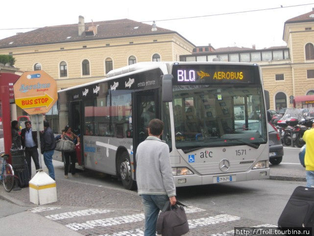 Автобус в аэропорт отваливает от остановки при железнодорожном вокзале Болонья, Италия