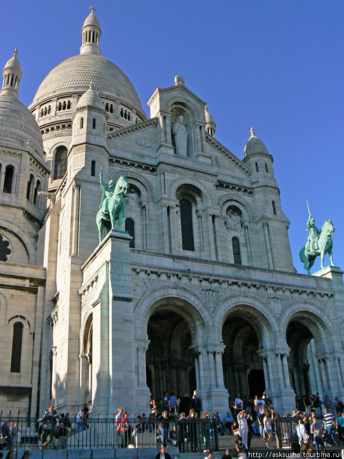 Фасад украшают бронзовые статуи Жанны д’Арк (справа от входа) и святого Людовика (слева). Над ними, в центре, возвышается белоснежная статуя Иисуса Христа, благословляющего Париж. Париж, Франция