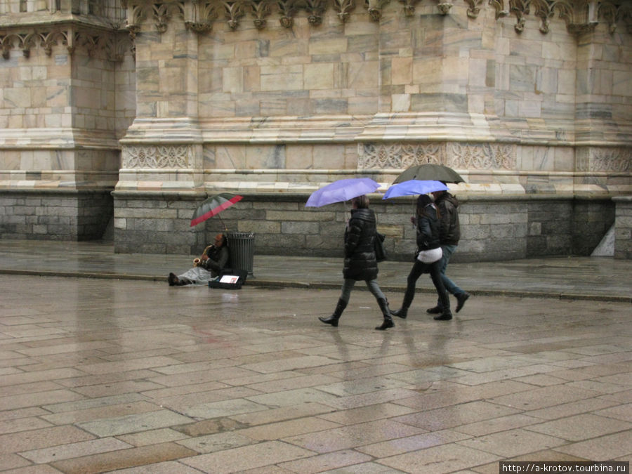 Под дождём играет музыкант Милан, Италия