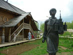 Памятник Ломоносову на фоне жилища из Архангельской области