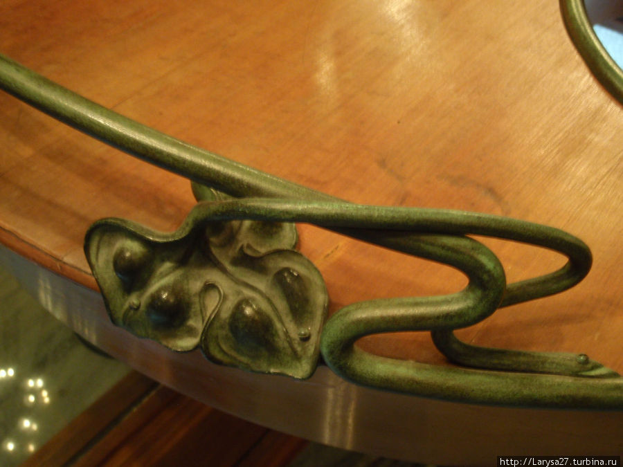 Бронзовая кованая деталь в виде листика и изогнутой веточки украшает мебель Бронзовая кованая деталь в виде листика и изогнутой веточки украшает мебель