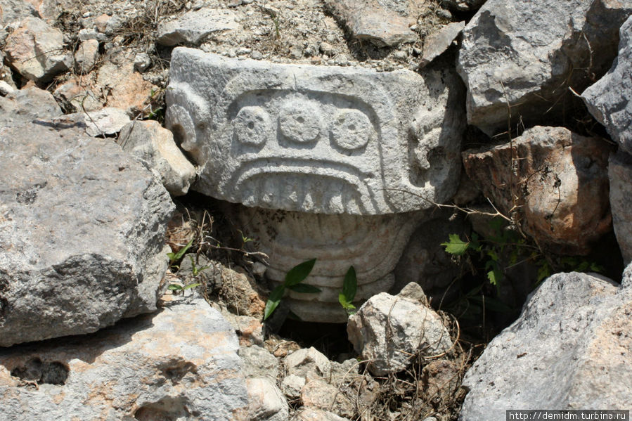 Камень с резьбой валяется в куче обычных камней Кабах, Мексика
