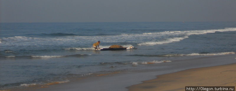 Рыбак пришвартовывается  к берегу Варкала, Индия