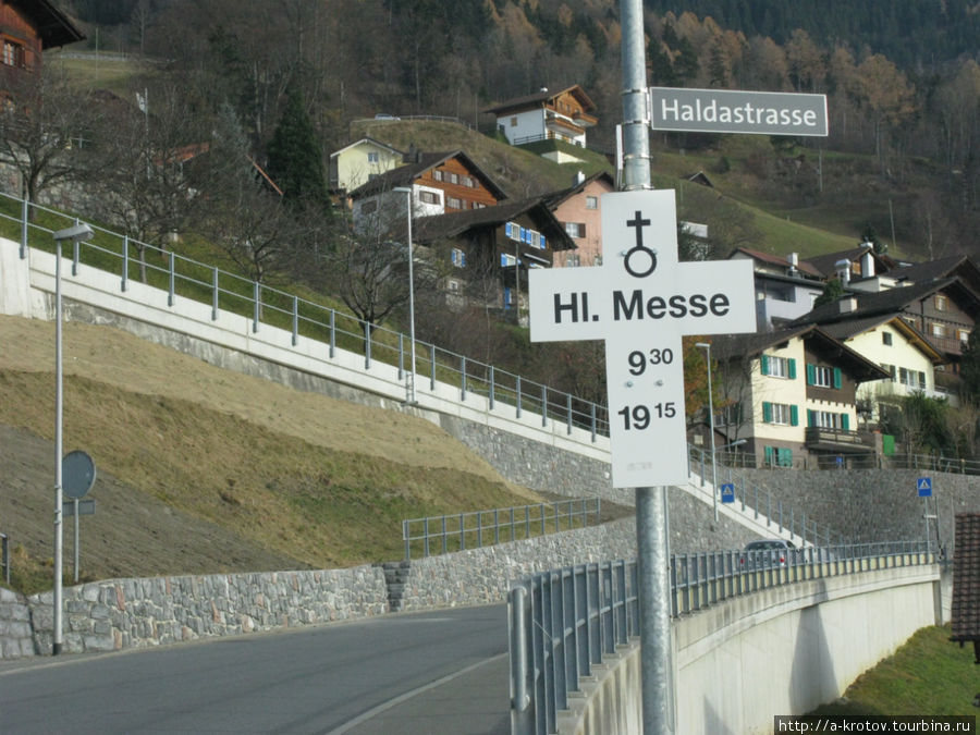 указатель на время святой мессы. Он есть перед въездом в разные населенные пункты Лихтенштейна Тризенберг, Лихтенштейн