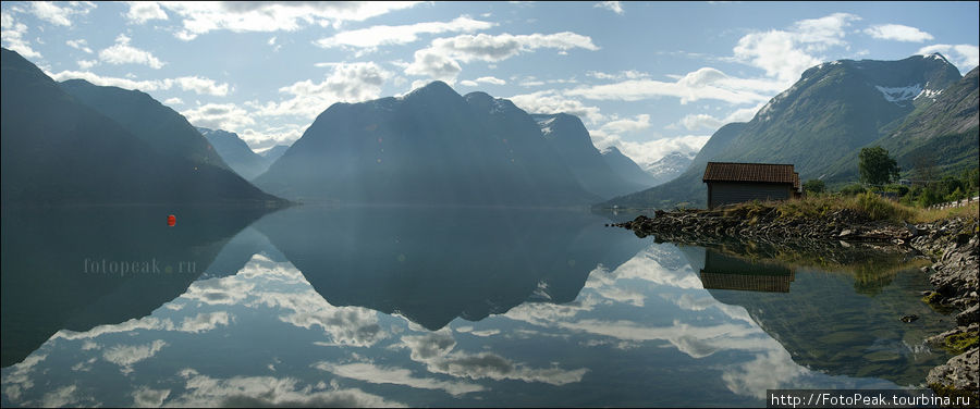 На озере полный штиль, поэтому отражение приобретает абсолютную зеркальность. Лишь маленький буек помогает сориентироваться где небо, а где земля.. Норвегия
