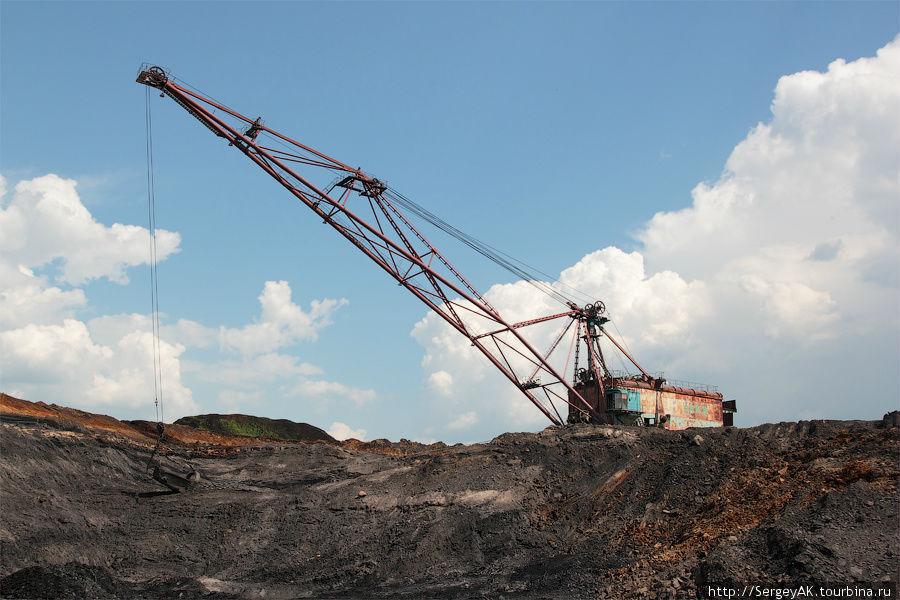 Шагающий экскаватор ведет вскрышную работу — снимает породу, скрывающую пласт угля Кимовск, Россия