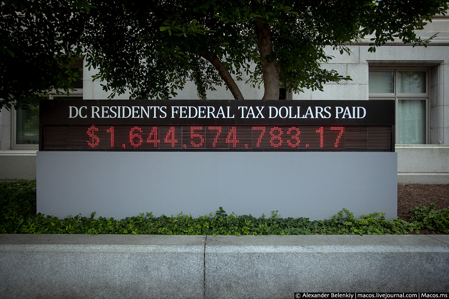 На улице стоит информационное табло, в реальном времени отображающее количество налогов, полученных от жителей федерального округа Колумбия. Вашингтон, CША