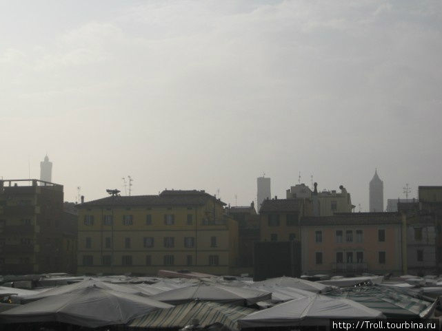 Удивительное сочетание современного рынка на переднем плане, полусовременных зданий на среднем и трех средневековых башен (а это именно они) на заднем Болонья, Италия