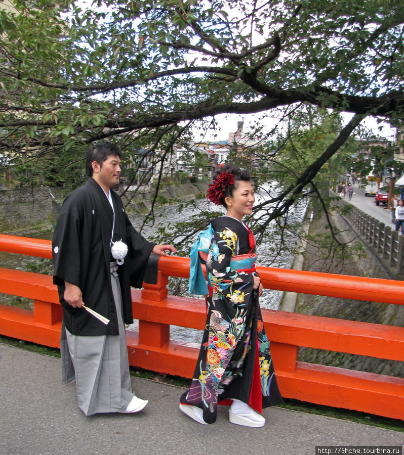 ... откуда пара колоритных японцев в национальных одеждах переходят в старый город Такаяма, Япония