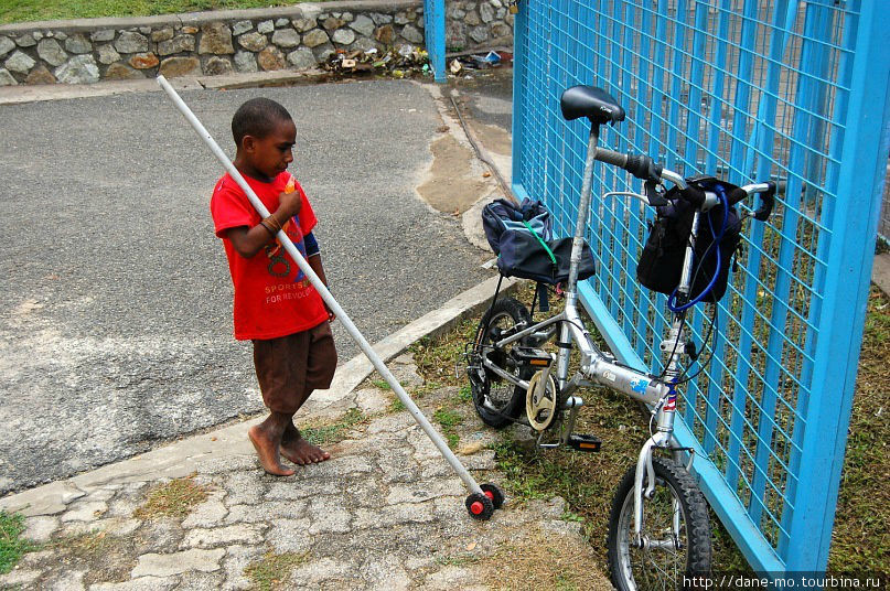 Мальчик разглядывает велосипед. Порт Морсби Папуа-Новая Гвинея