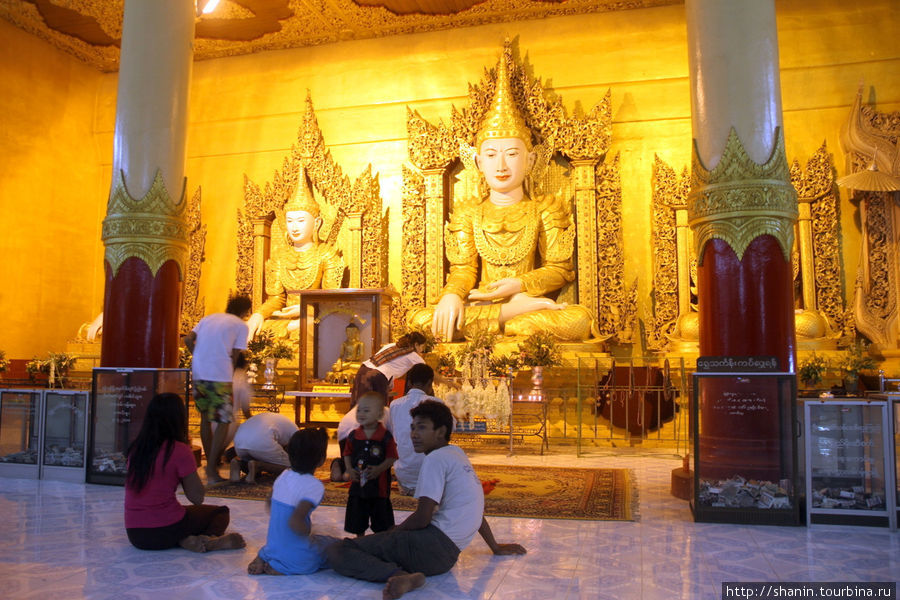 У статуй будды в главном храме пагоды Шве Сиен Кхон в Мониве Монива, Мьянма У статуй будды в главном храме пагоды Шве Сиен Кхон в Мониве Монива, Мьянма