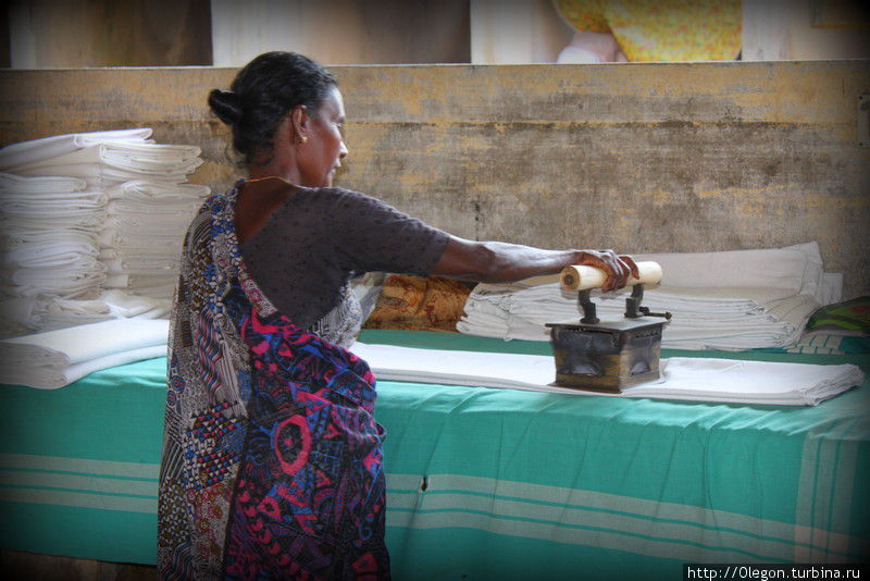 В руках хрупкой индуски тяжеленный утюг с углём Кочи, Индия