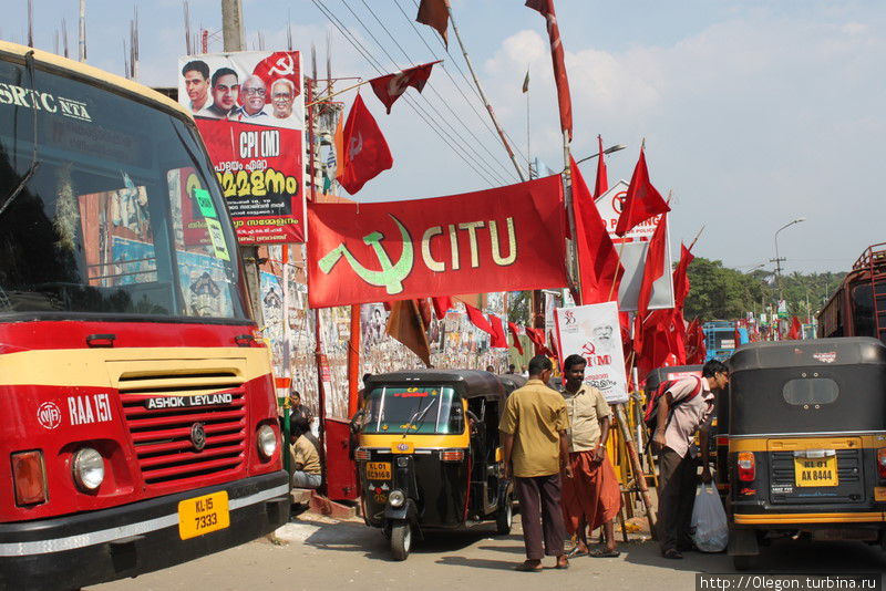 Красный автобус на фоне красных флагов Тируванантапурам, Индия