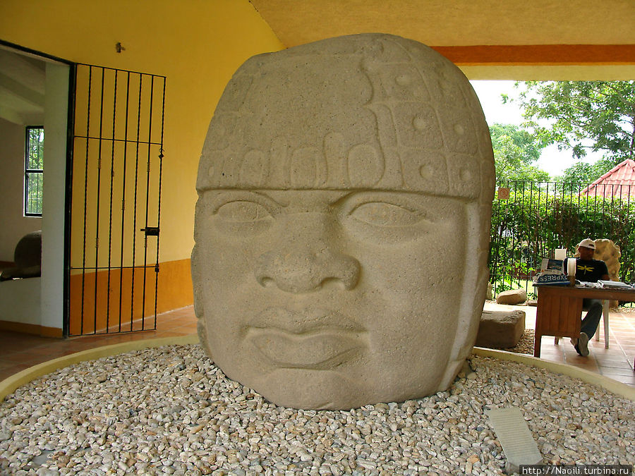 Колоссальная голова воина Ольмека в шлеме. Высотой 1,8 м