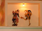 Куклы Арлекино украшают ниши в стене.